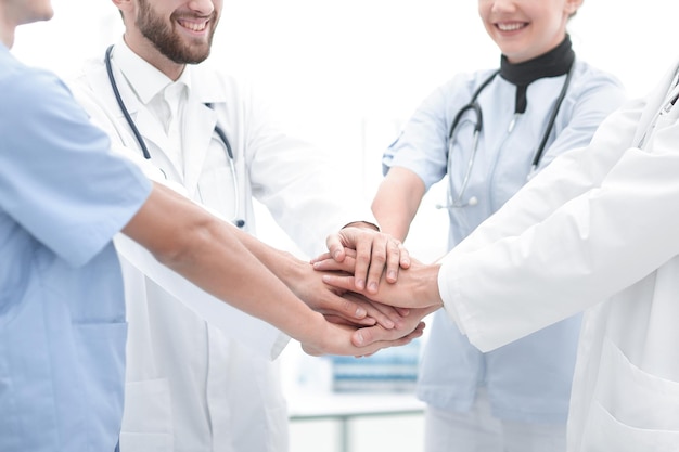 Doctors holding hands together at hospital