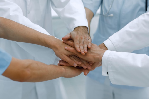 Doctors holding hands together at hospital