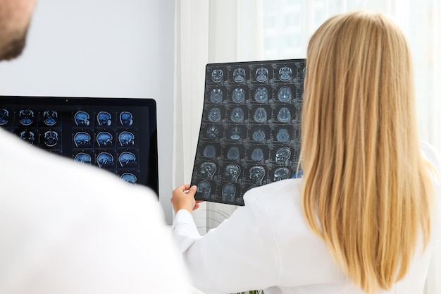 Photo doctors look at mri images of a human head