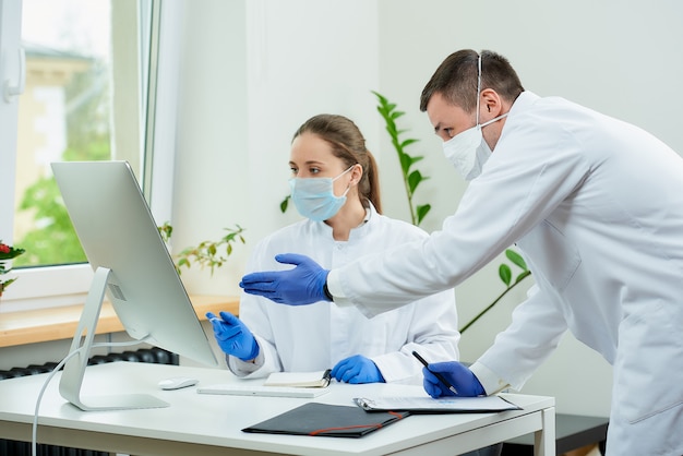 Doctors in medical masks discuss x-ray pictures of a patient