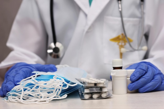 Photo at the doctors medical masks and medicines in the hands of a doctor