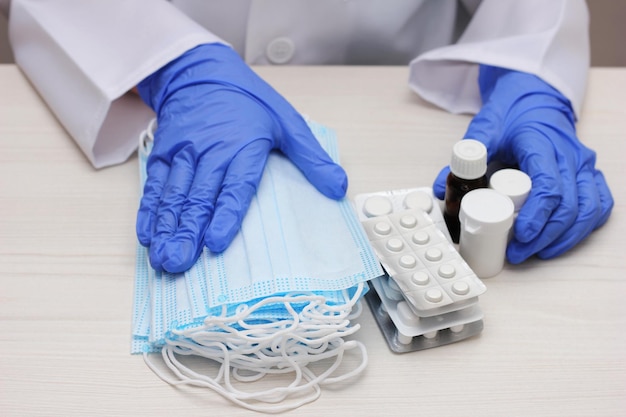 Photo at the doctors medical masks and medicines in the hands of a doctor