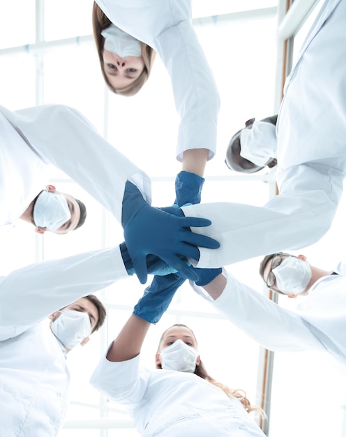 Doctors and nurses in a medical team stacking hands