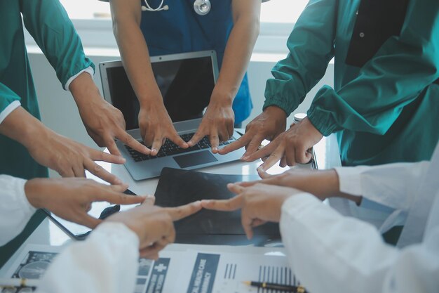 Photo doctors and nurses in a medical team stacking hands