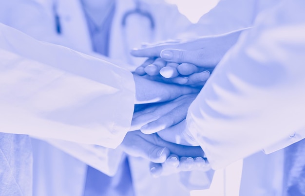 Doctors and nurses in a medical team stacking hands