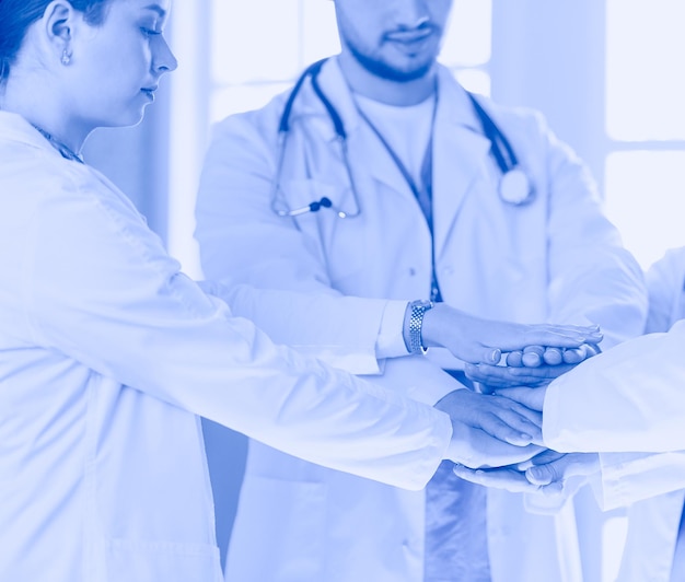 Doctors and nurses in a medical team stacking hands