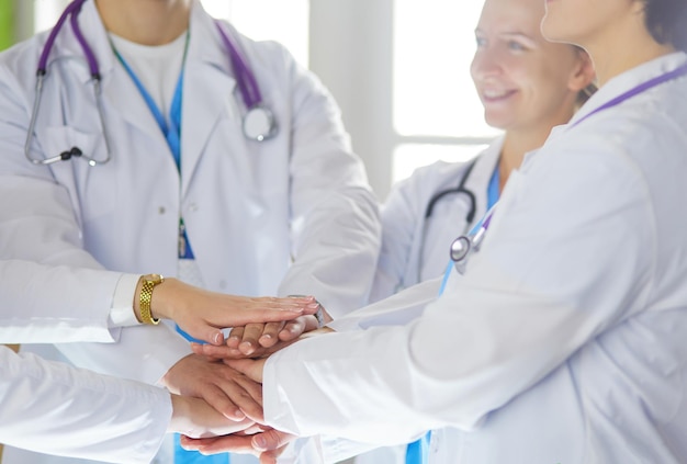 Doctors and nurses stacking hands Isolated on white