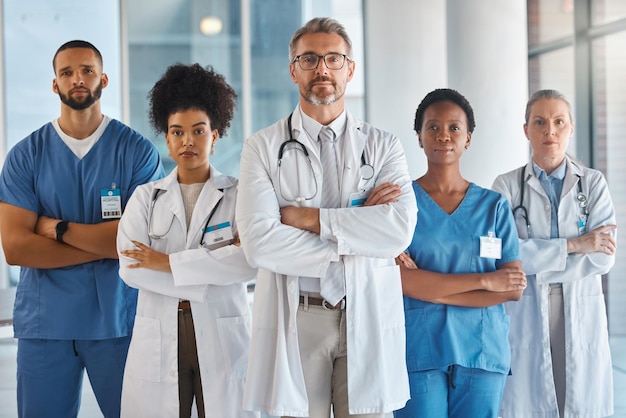 Doctors nurses and team portrait in hospital clinic or medical office Diversity health and healthcare professionals standing together arms crossed in confidence teamwork collaboration or support