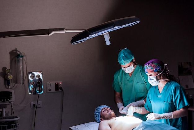 Doctors during operation in hospital operating room with patient