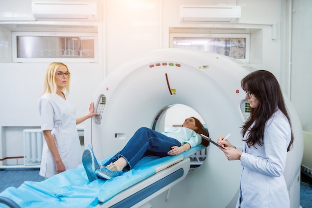 Doctors and patient in the room of computed tomography at hospital.