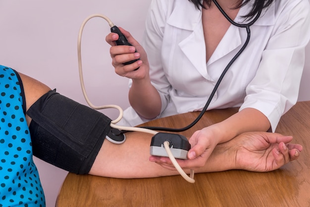 Doctors and patients hands with tonometer measuring blood pressure