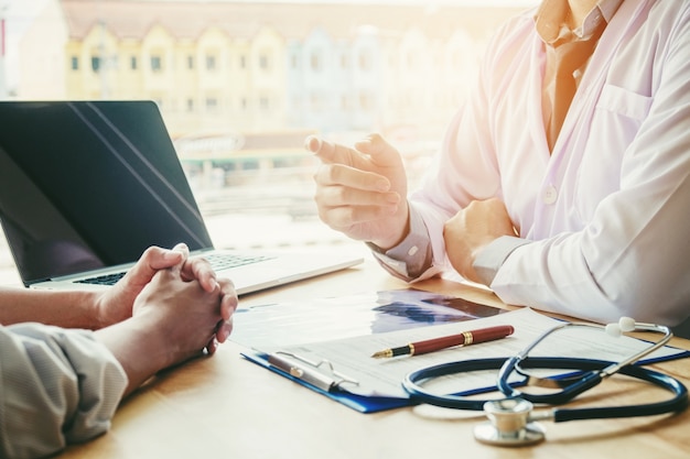 Medici e pazienti si siedono e parlano. al tavolo vicino alla finestra dell'ospedale.