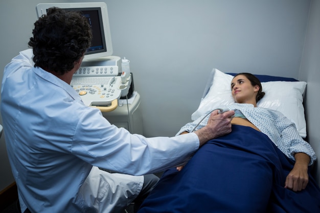 Doctors performing a doppler sonography on patient stomach