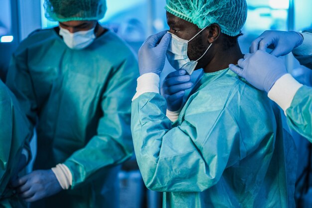 Medici che si preparano a lavorare in ospedale durante l'epidemia di pandemia di coronavirus - focus sul volto dell'uomo africano