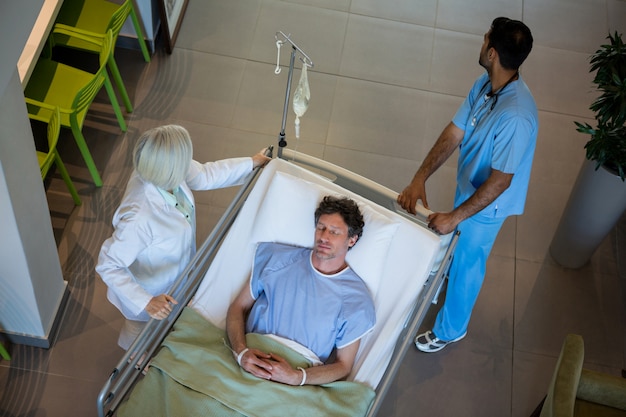 Doctors pushing emergency stretcher bed in corridor