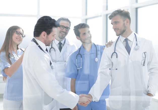 Doctors shaking hands in hospital corridor