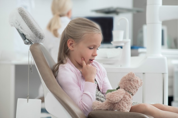 At the doctors. A small girl sitting in the dentist chair