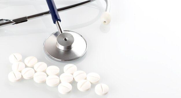 Doctors Stethoscope With pills isolated on the white background