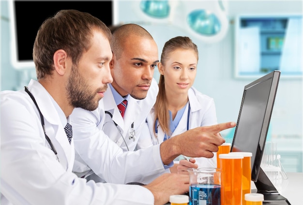 Doctors team talking expertise in hospital by laptop