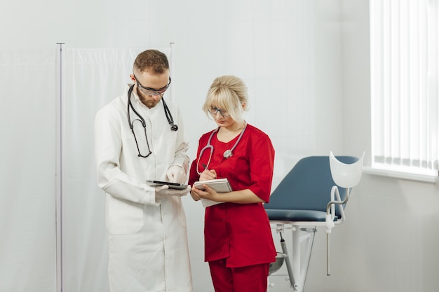 Doctors in uniform, man and woman in a gynecological office.