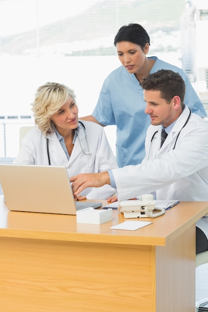 Doctors using laptop together at the medical office