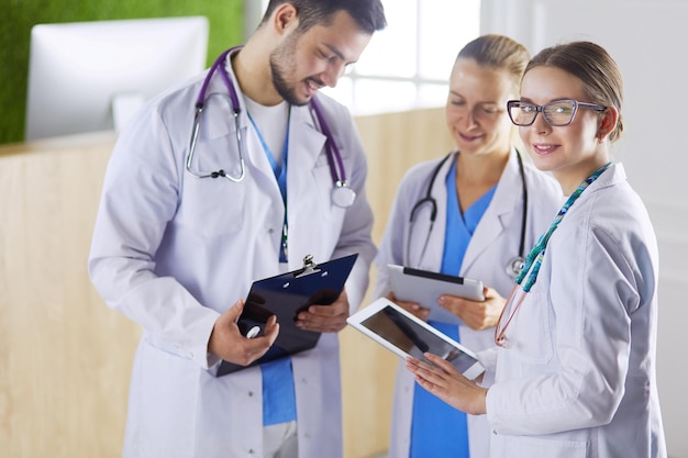 Doctors using a tablet in hospital standing in office