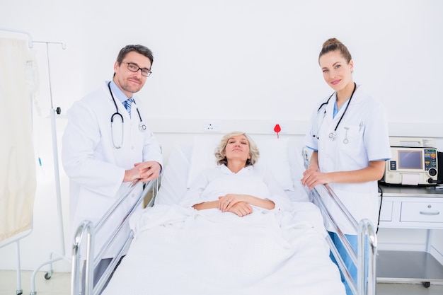 Doctors visiting a female patient in hospital