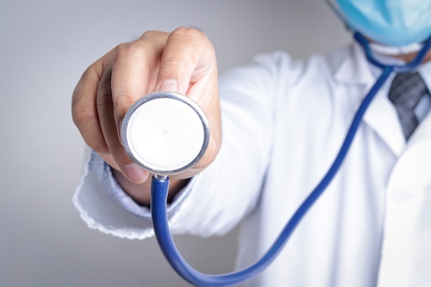 Doctors wearing masks and blue gloves. Hold a stethoscope to examine the patient