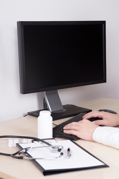 Foto posto di lavoro di medici con stethocsope e pillole del personal computer