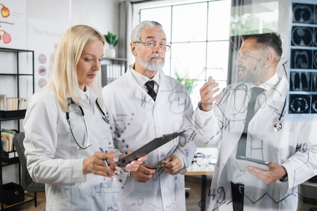 Doctors writing on flipchart while examining x ray scan