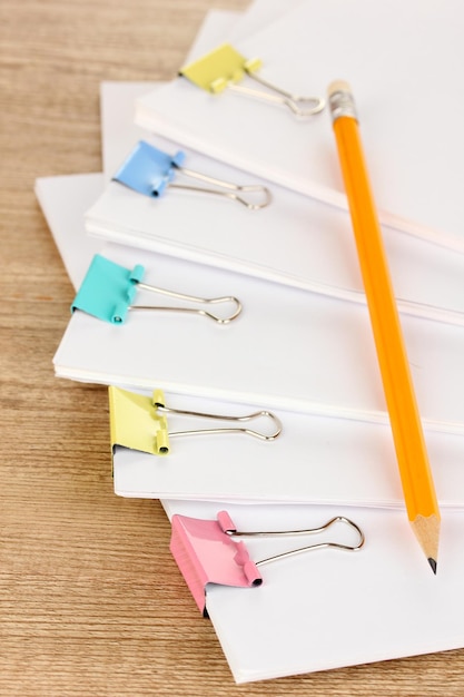 Documents with binder clips on wooden table