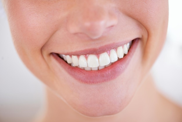 Does she brush her teeth 5 times a day. Close up of a womans sparkling teeth.