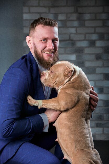 Dog bulli en haar baasje, haar liefhebbende meester die de hond in haar armen houdt, knuffels en kusjes. De hond voelt zich goed in de handen van de eigenaar