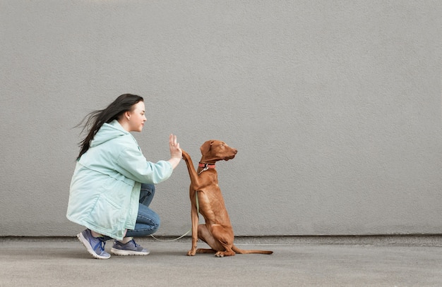 Dog geeft vijf meisjes. opgeleide puppy voert teams uit.