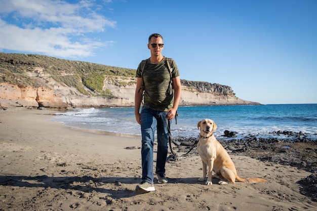 A dog and his owner during a walk on the beach traveling boy with pet companion