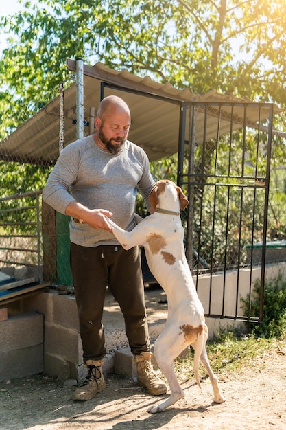 Dog jumping on top of a man petting him