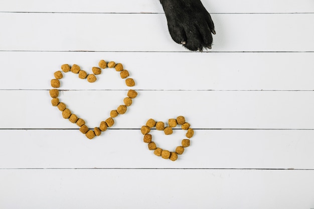 Dog paw near hearts from food