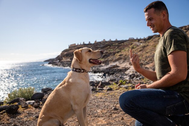 A dog trainer gestures with his hand in front of a dog during a training session