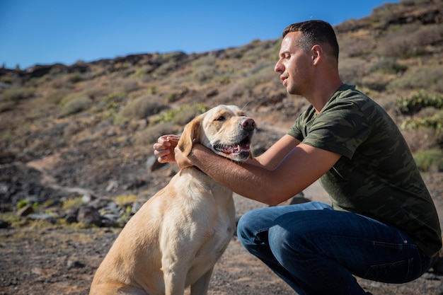 A dog trainer puts the collar on a golden retriever photo with copy space