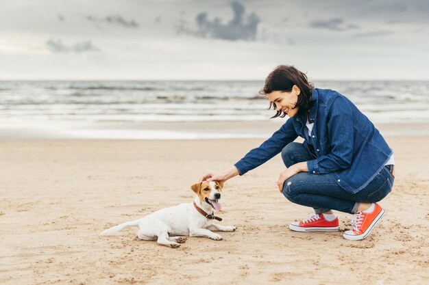 Dog and woman on seashore