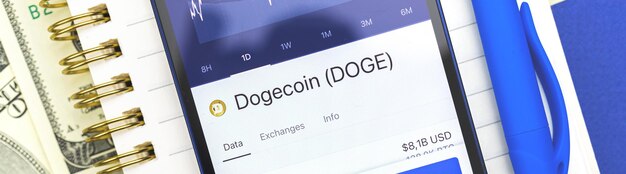 Dogecoin DOGE cryptocurrency op de schermbanner die smartphone gebruikt voor het kopen van cryptomunten, zakelijke en financiële conceptfoto