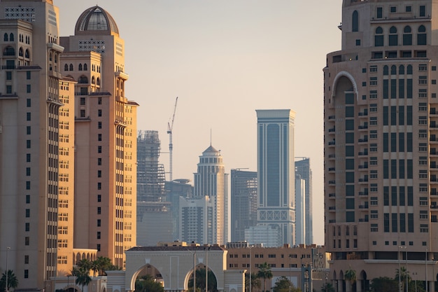 Доха, Катар, городской пейзаж современных, но все еще старых школьных зданий во время заката.