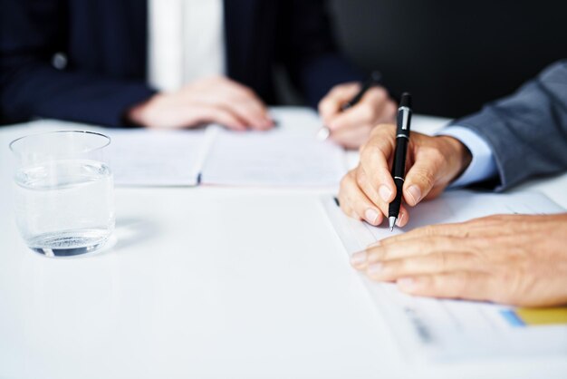 Doing a business handover Cropped shot of businesspeople working on paperwork