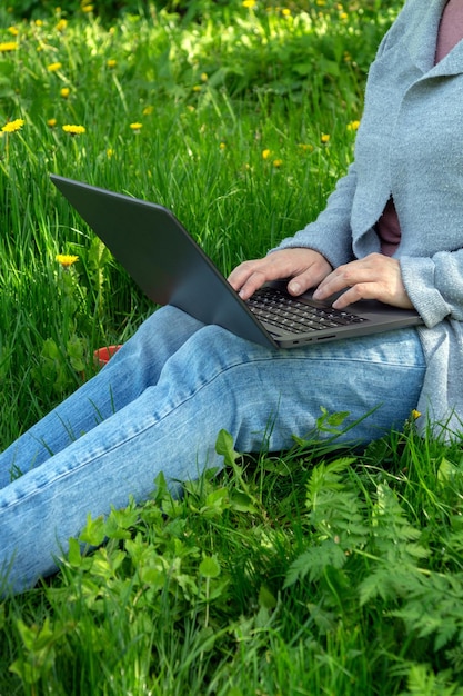 Doing business outdoors among nature Closeup of woman hands with laptop