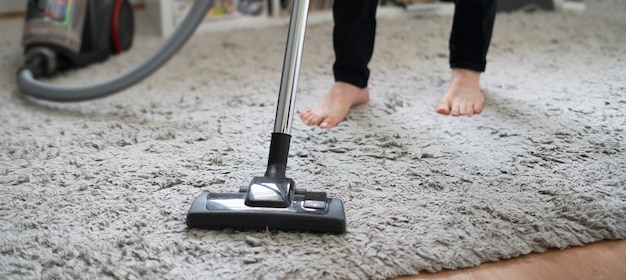 Doing a clean up at home using vacuum cleaner to wash the floor