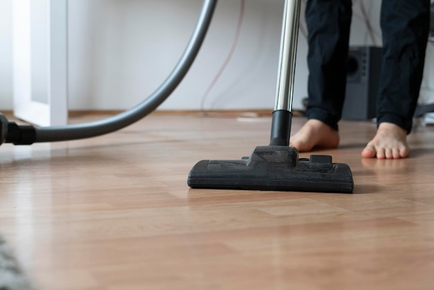 Doing a clean up at home using vacuum cleaner to wash the floor