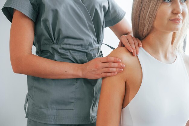 Doing massage Woman is in health center getting help by doctor