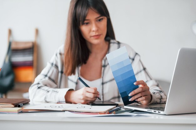 Doing paperwork Young female freelance worker is indoors in home at daytime