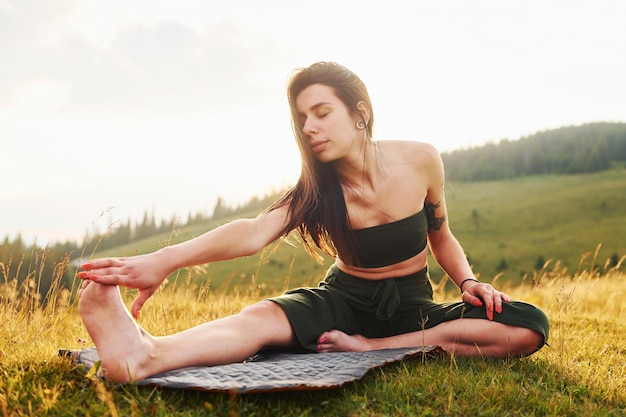 Fare yoga all'aperto bella donna maestose montagne dei carpazi bellissimo paesaggio di natura incontaminata