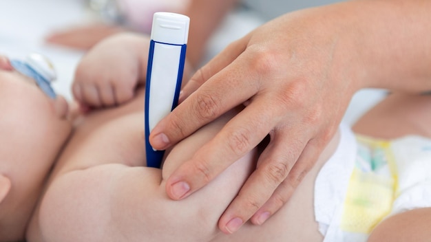 Dokter die de temperatuurkoorts controleert op kleine pasgeborene met thermometer